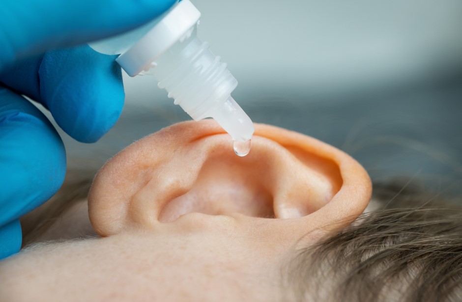 Woman getting ear drops inserted into her ear